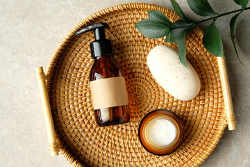 Set of natural SPA cosmetics and green plant branch in rattan plate.