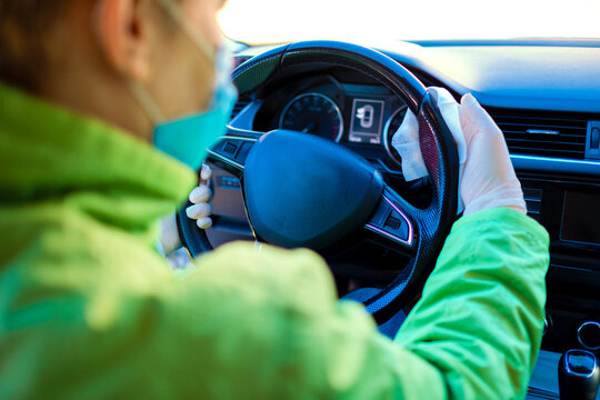 Woman Wearing Green Jacket And White Glove Cleaning Car With Antibacterial Wipes