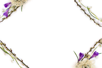 Spring frame of twigs willow tree with catkins, snowdrops, violet crocuses and quail eggs on light background with space for text. Top view, flat lay