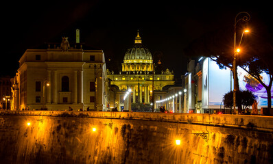 Fototapeta premium Imagen nocturna de la Via della Conciliazione desde el puentre de Vittorio Emanuele II, con la basílica y la cúpula de San Pedro, en el Vaticano, al fondo.