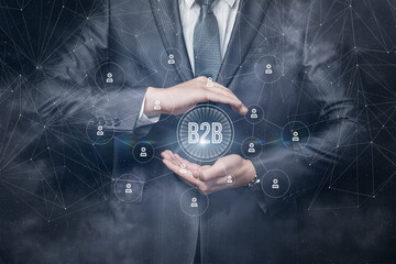 Businessman protects business to business model on blurred background.