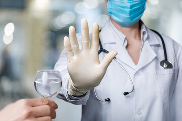 Doctor prohibits drinking alcohol with hand gesture .