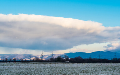 Big cloud like in movie "Independence day" in blue sky over winter landscape