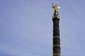 Fototapeta na wymiar Vorderansicht Siegessäule Berlin, Sonnenschein, milchig blauer Himmel, freie Fläche