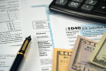 Blank Form 1040 U.S. Individual Income Tax Return with Pen and banknotes. Selective focus