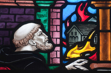 Monk looking out in stained glass
