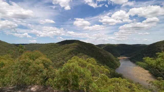 Beautiful panoramic video of a mountain top lookout of a creek with mountains and valleys on all sides and deep blue sky with puffy clouds, Naa Badu Lookout,  Sydney, New South Wales, Australia