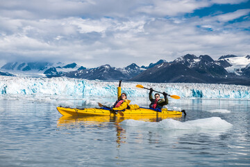Happy couple enjoys ocean kayaking bear glacier during their vacation trip to in Alaska, USA - 415014175