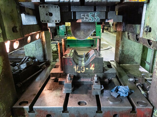 Fototapeta na wymiar dirty used low tech stamping press with sheet metal die tooling