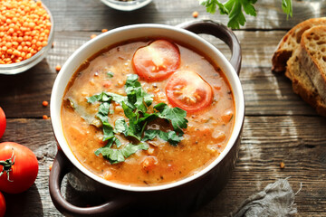 Red lentil soup and ingredients. Wooden background. Traditional spicy soup made from lentils and vegetables. Healthy vegan food