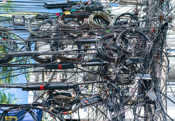 Chaos of cables and wires on an electric pole. Many electrical cable - wire and telephone line on electricity post. Wire and cable clutter