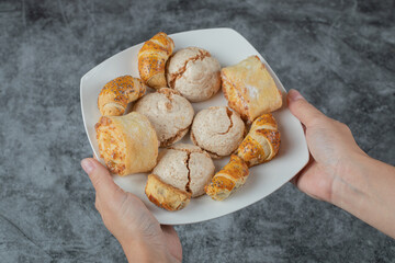 Chef holding crispy cookies with sugar powder in the hand