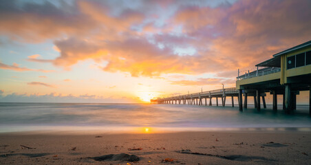 Fototapeta na wymiar sunrise beautiful beach summer bridge sand sea water reflections sun florida sky clouds colors sunset 