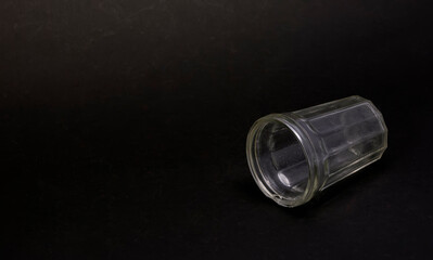 Faceted glass lying on black background