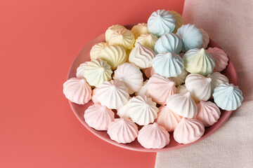 Sugar protein multi-colored dessert in pastel colors in pink plate on a pink background. Linen napkin. Close-up