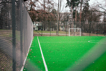 School soccer stadium. Empty soccer field behind the iron fence