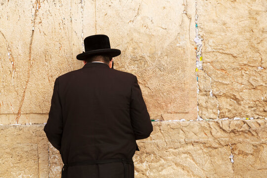 A Jewish man wearing Orthodox clothing prays by the Western Wall (Wailing Wall), Jerusalem, Israel