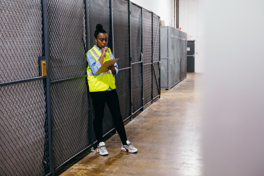 African American woman in datacenter surveying warehouse is secure