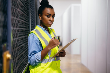 African American woman in datacenter surveying warehouse is secure
