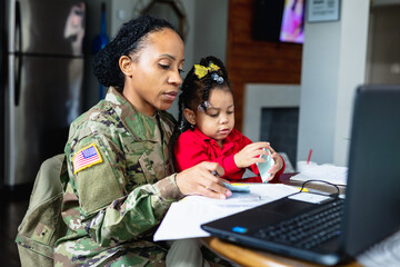 Focused military woman working from home at laptop