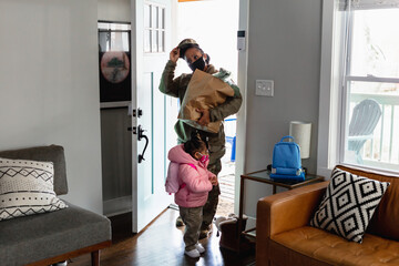 Female mother soldier brings home groceries with daughter