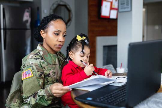 Focused military woman working from home at laptop