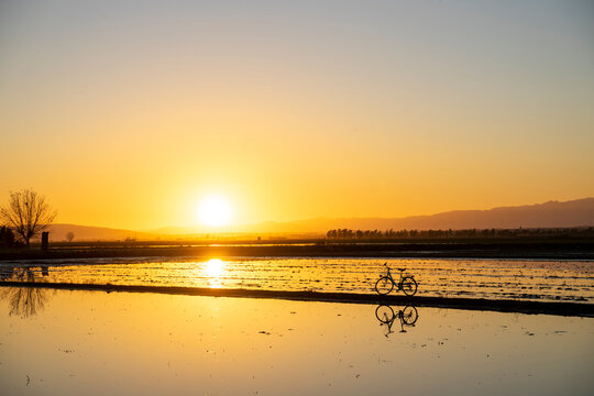 Reflection of bicycle seen at Ebro Delta during sunset, Spain