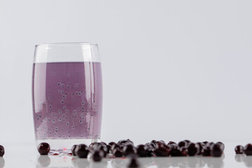 Blackcurrant confiture with a glass of juice on a white background