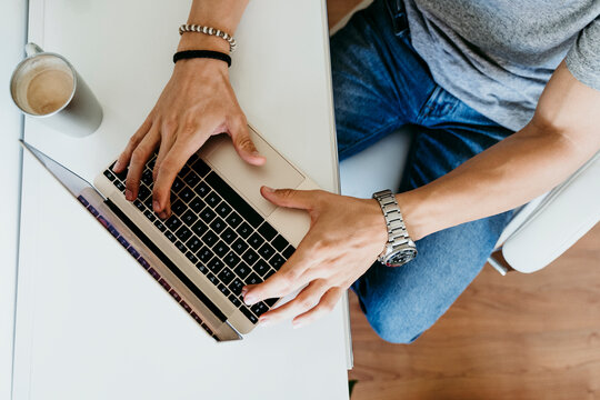 Top view of man working on laptop at home