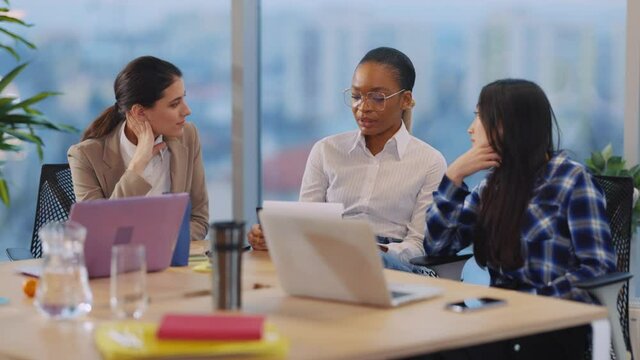 Company of international young women discussing corporate plans for next mans negotiating in boardroom. Business people. Office company.