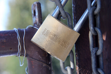Word Lockdown, detail with door lock engraving and safety chain as a Covid-19 pandemic business...
