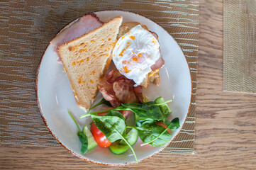 morning fresh breakfast toast with poached egg vegetables bacon on a plate