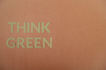 Think Green cardboard letters on a craft paper