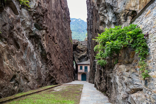 Empty footpath amidst soapstone cliffs at quarry in Parco Archeologico Botanico del Paradiso, Valchiavenna, Chiavenna, Province of Sondrio, Lombardy, Italy