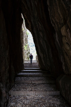 Male tourist exploring amidst soapstone cave at quarry in Parco Archeologico Botanico del Paradiso, Valchiavenna, Chiavenna, Province of Sondrio, Lombardy, Italy