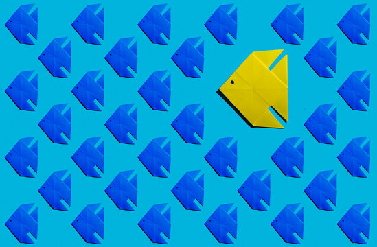 Pattern of blue origami fish with single yellow one