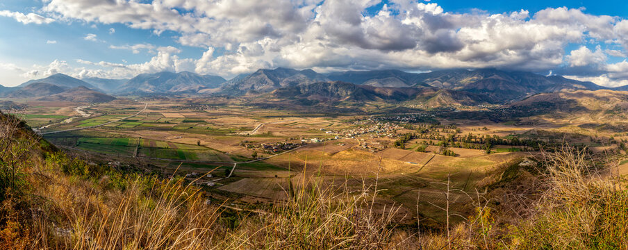 Albania, Vlore County, Finiq, Panorama of brown hilly landscape in summer with village in distant background