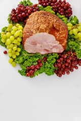 Smoked whole pork ham with fresh fruits. Healthy food.