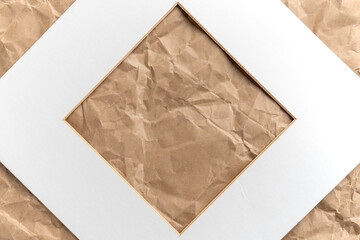 Paper white square cardboard frame on crumpled brown kraft paper