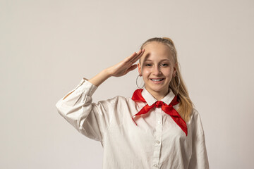 Teenage girl with bologna hair and pioneer tie on a light background raise her hand. high quality