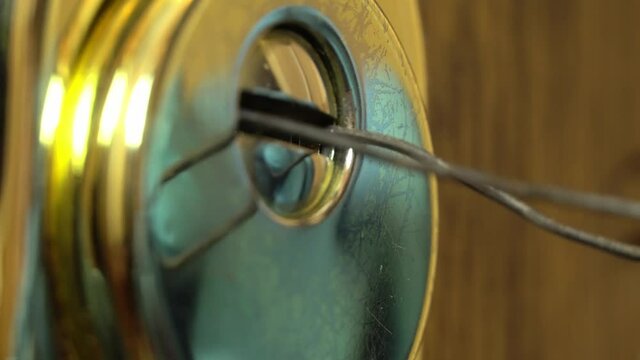 Gloved hands open the lock with a master key. A man opens the lock to the apartment. It can be both a locksmith and a thief, a robber.