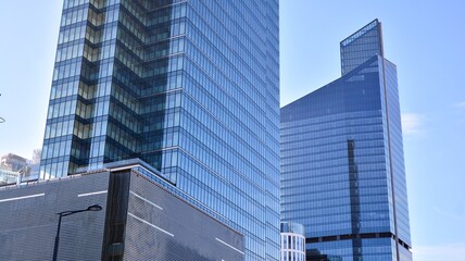 Facade texture of a glass mirrored office building. A beautiful background of an glass office building, reflecting clouds in the windows.