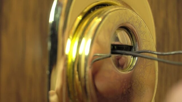 Gloved hands open the lock with a master key. A man opens the lock to the apartment. It can be both a locksmith and a thief, a robber.