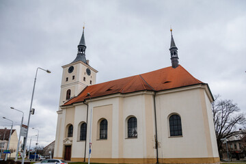 Fototapeta na wymiar Baroque church of St. Mary Magdalene with clock tower at main Masaryk Square in city centre, spa resort in winter day, Lazne Bohdanec, Pardubice region, Czech Republic