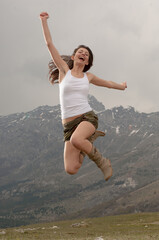 Ragazza salta felice in montagna
