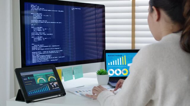 Back rear view of young asian woman, freelance data scientist work remotely at home coding programing on Big data mining, AI data engineering, IT Technician Works on Artificial Intelligence Project.