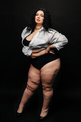 Plus size model in lingerie, fat sexy woman in underwear on black studio background, body positive concept, full length portrait