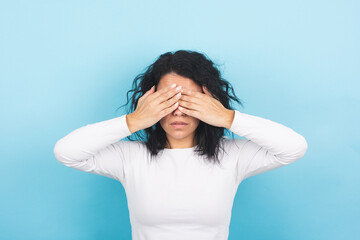 Young brunette woman covers her eyes with her hands