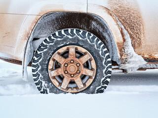 Closeup of all-terrain tire and wheel of dirty 4x4 SUV car or truck  - winter travel and recreation concept