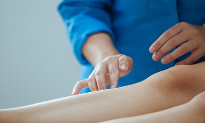 Mãos pressionando pernas do paciente